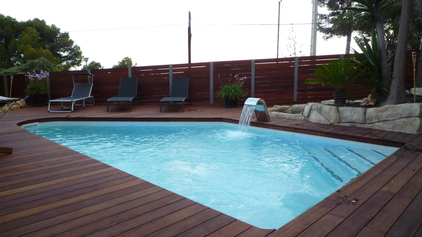 Piscina rectangular con zona de tumbonas